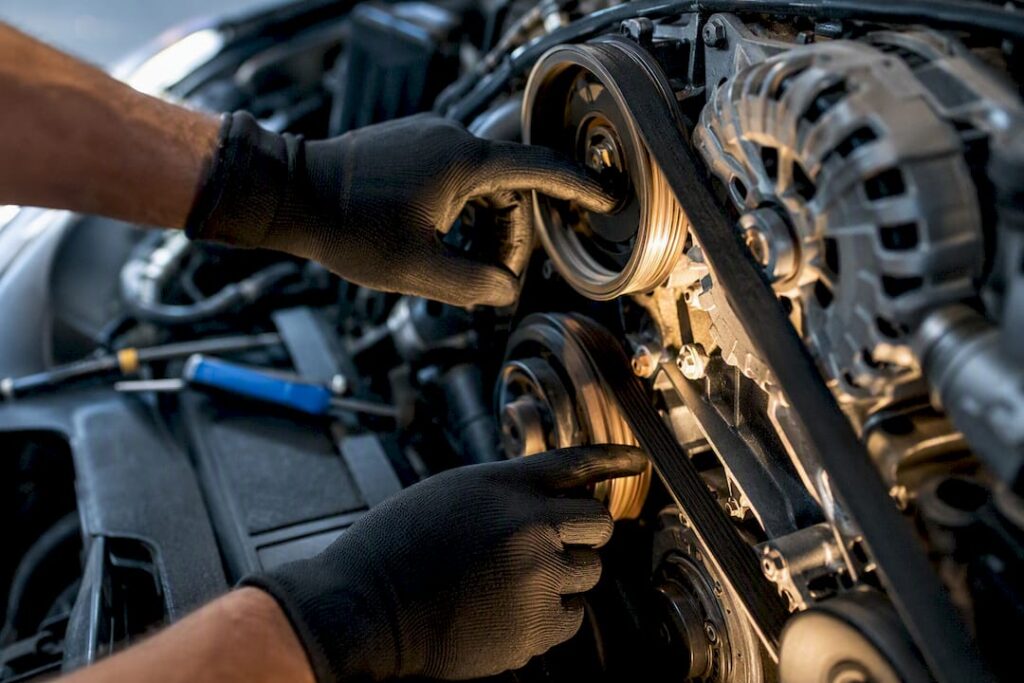 Mechanic inspecting serpentine belt and pulley
